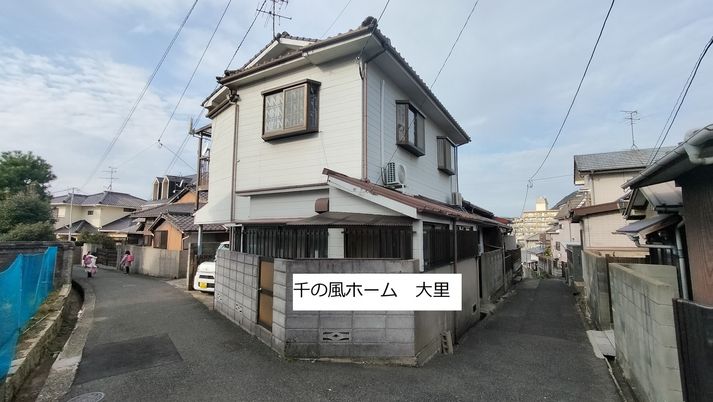 三角屋根で白い外壁の2階建て住宅