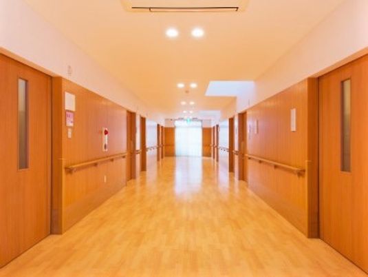 幅の広い高齢者施設内の廊下の写真。両側に歩行用の手すりがついている様子