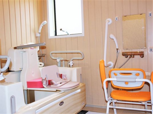 シャワーチェアやリフト付きの浴槽が設置されたお風呂。窓が付き明るい。