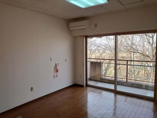 エアコンが付いたフローリングの部屋には緊急通報装置があり、大きな窓の外にはベランダもある。