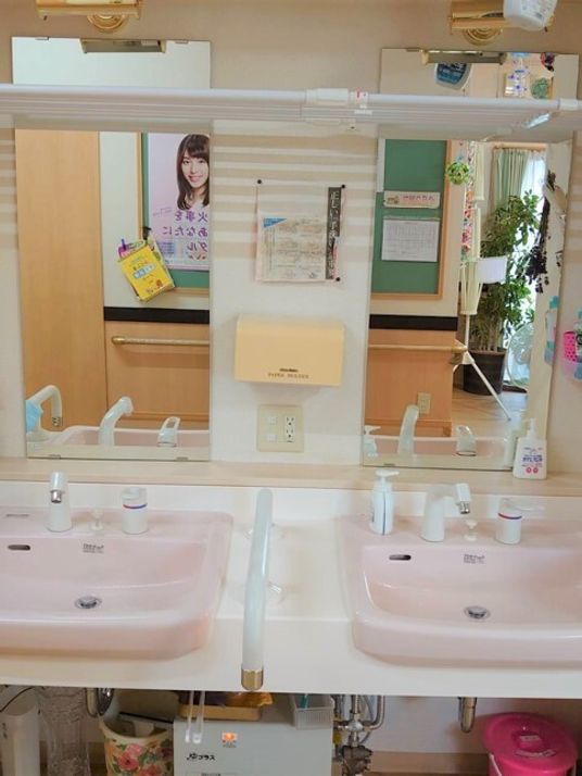 手すり付きの洗面台がならんでいる施設内の共有スペース内の様子