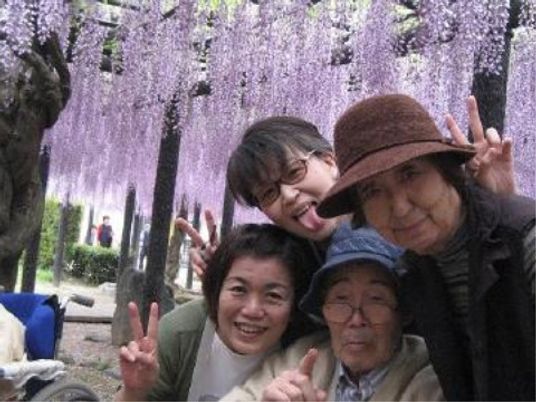 笑顔の人々と紫の花