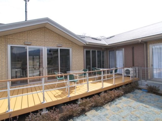 明るい庭のテラス ガーデンテラス 日差しが心地良いテラスで、ご利用者様はリラックスされています。