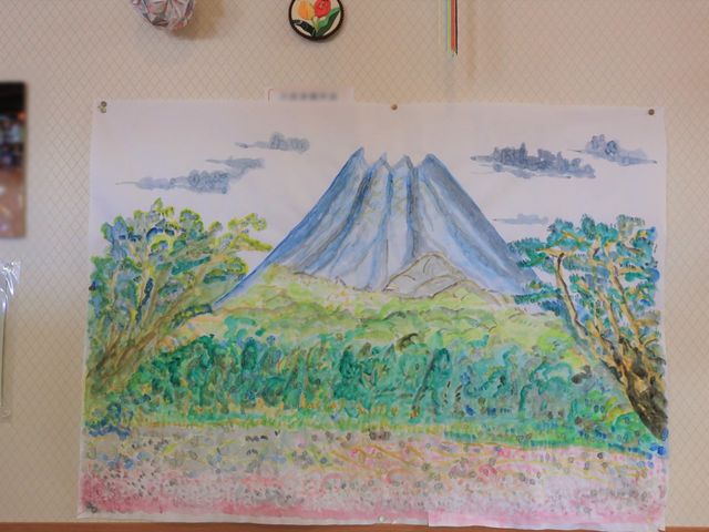 壁に掛かる手描き風景画 展示物 壁に飾られた風景画が、日々の業務に温かな彩りを添えています。このような環境で、皆様の生活をサポートしたいと思われる方にはぜひおすすめです。