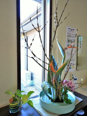  窓辺の生け花と緑  