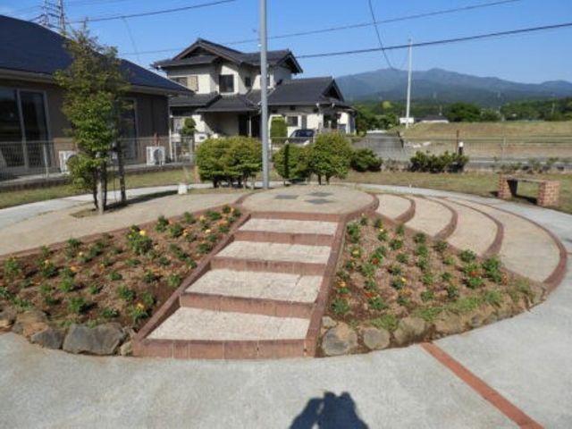 庭園の段差スペース庭 庭   段差のある花壇スペースと、周囲を囲むゆるやかな通路が見えます。屋外で気分転換しやすい環境づくりが感じられます。