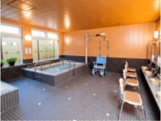 広々とした明るい浴室 大浴場 広々とした空間は明るい昼光が差し込み、ゆったりとした入浴時間を提供しています。バリアフリーの構造で、どなたでも安心してご利用いただけます。