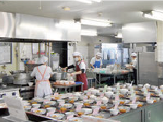 調理風景のキッチン キッチン 調理スタッフが活気あるキッチンで作業中です。清潔で効率的な環境が整っています。