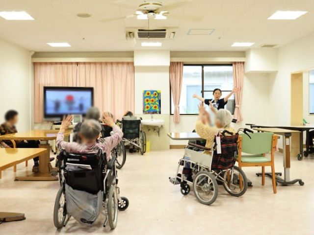 明るい共有スペース ラウンジ 光が差し込むラウンジでは、利用者が車椅子に座りながら、リラックスした時間を楽しんでいます。