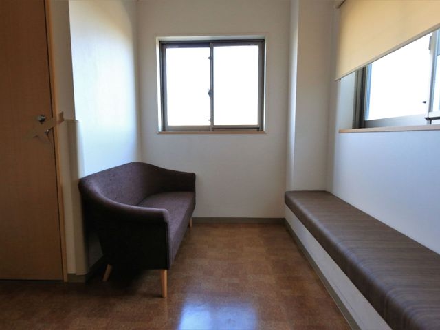 シンプルな居室のコーナー 廊下 すっきりとした空間の居室です。日当たりの良い窓辺には、ゆったり座れる椅子が配置されています。