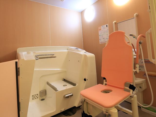 浴室と介護用椅子 特殊浴 清潔感のあふれる浴室の一角です。広々とした空間には、サポート機能付きの介護用シャワーチェアが備えられ、安全で快適な入浴を支援します。
