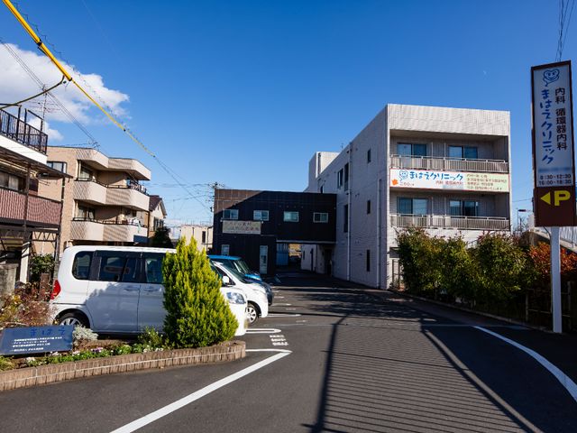 晴れた日の施設外観 外観 青空の下、清潔感ある建物の前には駐車スペースも整っており、アクセスしやすい立地条件のようです。