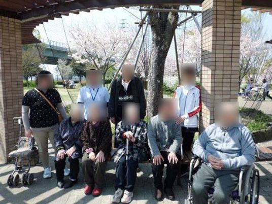 屋外で椅子に座る人々