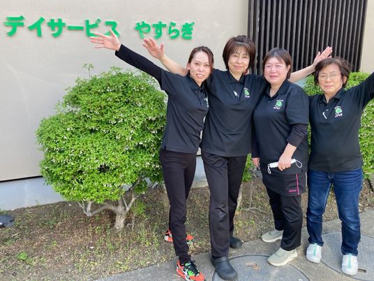笑顔の職員が並ぶ外観  