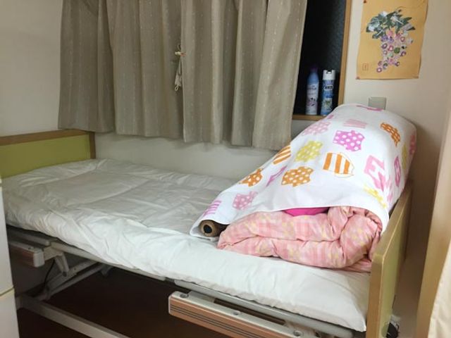 シンプルなベッドの居室 居室 安全設計のベッドが設置された居室で、リラックスして過ごせます。収納スペースも便利です。