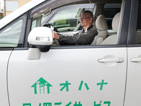 送迎車の運転席の男性  