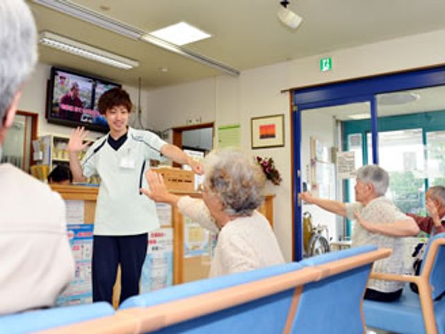 楽しい活動が行われる居室 居室 スタッフのリードで、明るい居室で体操が行われています。楽しげな雰囲気が広がっています。