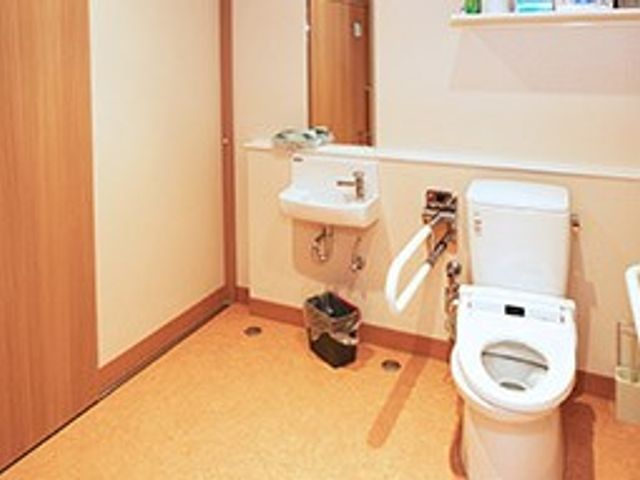 清潔感のあるトイレ トイレ 広々とした設計のトイレで、手すりが設置され安心して利用できます。