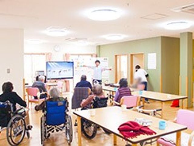 リラックスできる空間 多目的室 広々とした明るい空間で、皆さんが和やかな雰囲気の中でアクティビティに参加しています。