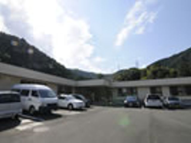 駐車場のある建物外観 外観 山に囲まれた落ち着いた場所に位置するこの建物は、車の停めやすい駐車場があります。