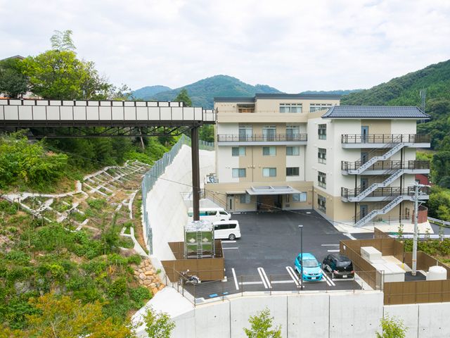 緑豊かな全景 外観 自然に囲まれた施設の広々とした駐車スペースです。周りの緑が癒しを提供します。