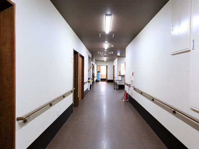 明るく清潔な廊下 通路  手すりが備わった廊下は、安全に配慮された設計で、作業効率も考慮されています。職員と利用者の笑顔が交わる場所です。
