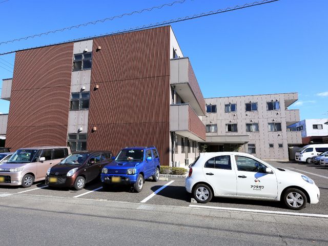 モダンな建物と駐車場 駐車場  清潔感のあふれる外観の建物です。ゆとりのある駐車スペースがあり、快適な環境が整っています。