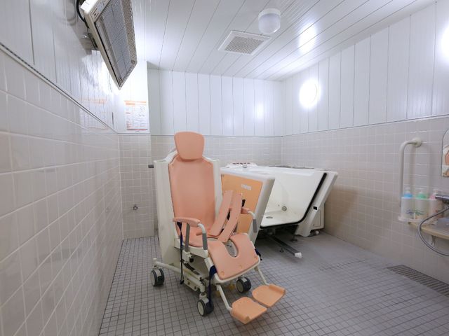 バリアフリー設計の浴室 介護浴槽 十分なスペースと手すりが設けられ、チェアリフト付きのバスタブが、ご利用者の快適な入浴をサポートしています。