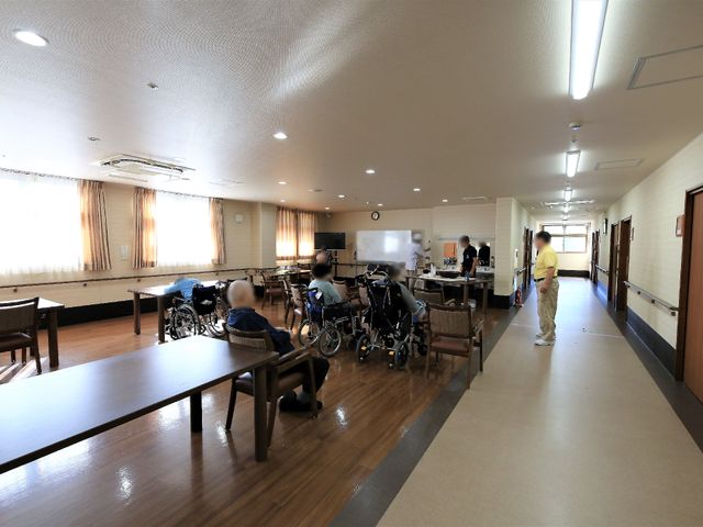 共有スペースの日常風景 共有スペース ゆとりのあるダイニングルームでは、利用者の方々がリラックスしながら食事を楽しまれています。職員も笑顔で寄り添う、温かい雰囲気が感じられます。