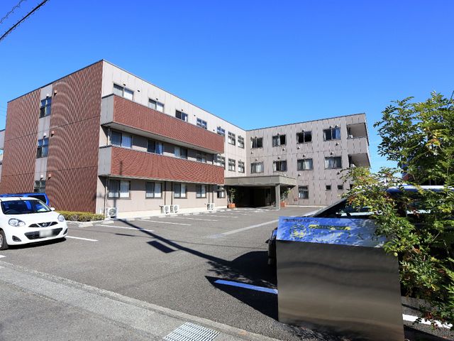 日差しの中の建物外観 外観  陽光が差し込む快適な立地に位置する当施設で、充実した職場環境をご提供いたします。