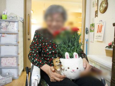 笑顔の人物と植物がある居室