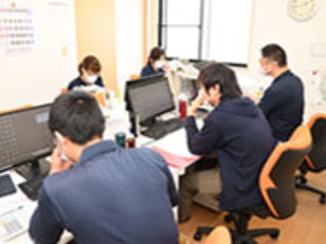 デスクワークの様子 スタッフイメージ スタッフがデスクで作業しています。オフィスでのチームワークの良さが感じられます。