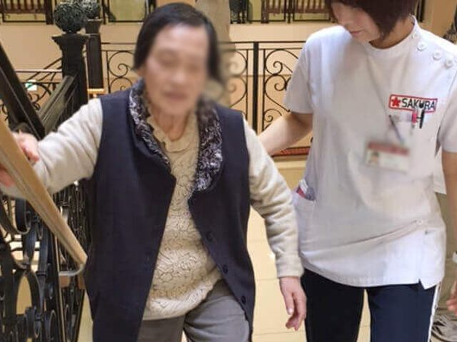 サポートの様子廊下 廊下 手すりを活用し、安全に移動をサポートする様子です。介護現場での協力が感じられます。