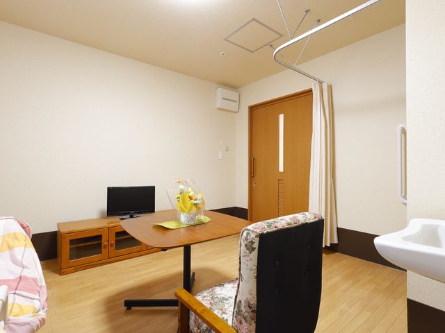 居室の様子を表す 共有スペース 清潔感のある居室には、日々のくつろぎに必要な家具が揃っております。手すりやスペースも考慮された設計です。