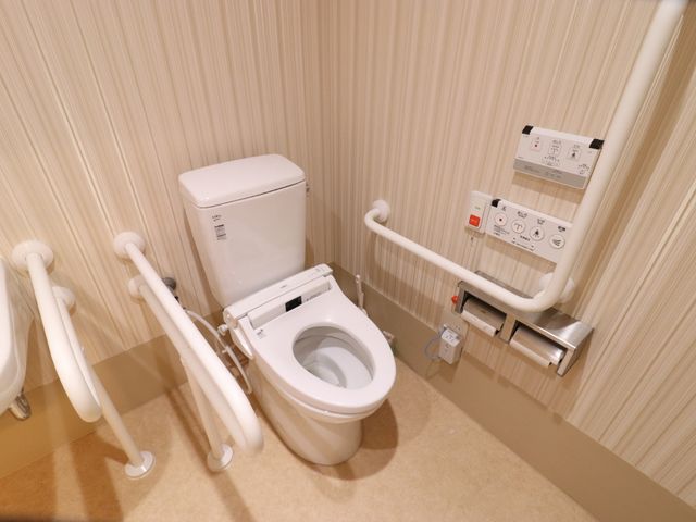 バリアフリーのトイレ設備 トイレ 手すりが設置された清潔なトイレ空間です。安全と快適さを考慮したデザインで、安心してご利用いただけます。