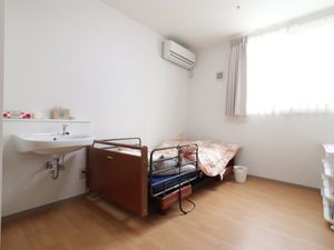 洋室のベッドと洗面台