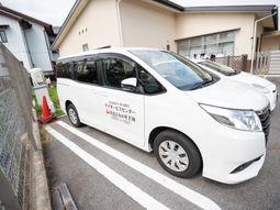 送迎車と施設外観