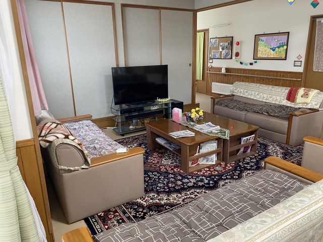 共有スペースの和室 居室 和の趣を感じる居室で、ゆったりとテレビを見ながら寛げる空間です。ソファや座椅子が配置され、落ち着いた雰囲気が伝わります。