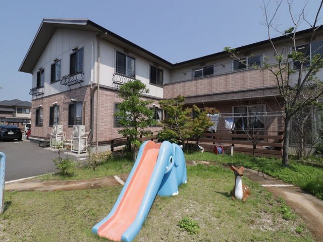 明るい外観の建物 外観 開放感のあふれる空間が印象的な建物外観です。子ども用の遊具があり、訪れるご家族にも楽しんでいただける環境が整っています。