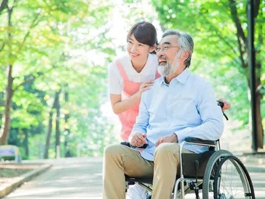 車椅子の男性と笑顔の女性