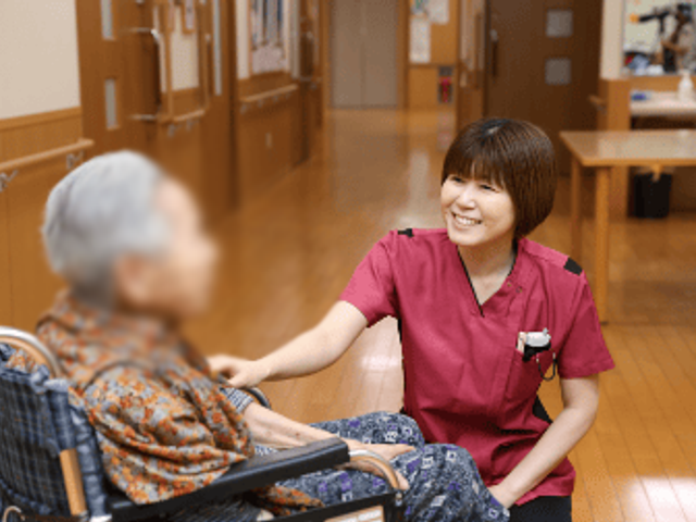 優しいスタッフの様子 廊下 スタッフが笑顔で対応する風景です。温かな雰囲気の中で安心して働けます。
