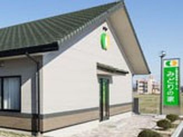 緑の看板の建物外観 外観 ゆったりとした空間が特徴の施設です。温かみある色合いの外観が印象的です。