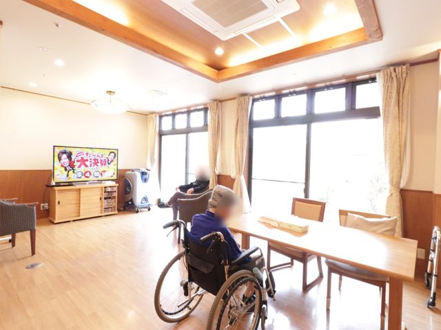 リビングにテレビと車椅子 リビング 暖かみのあるリビングで一息つきながら、こちらの天井が高めの明るい空間でリラックスして過ごすことができます。