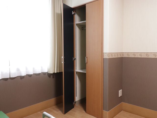 居室のクローゼット開放 居室内収納 暖かみのある色合いの居室で、開閉しやすい広々としたクローゼットが完備されています。個々の収納ニーズに対応し、快適な生活空間を提供しています。