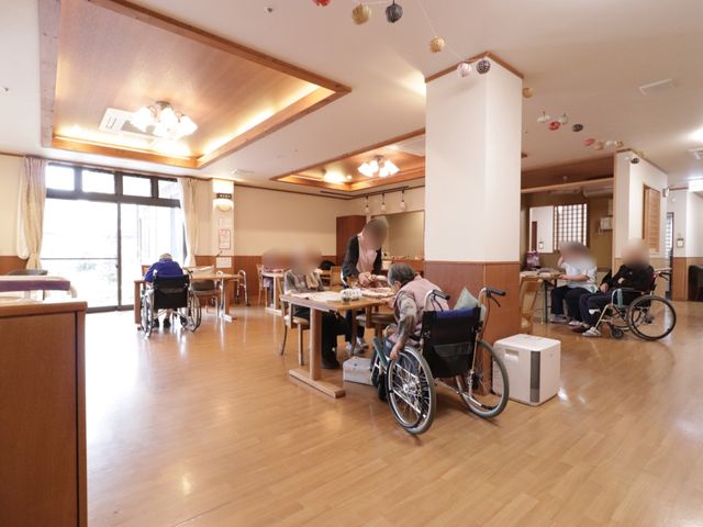 広々とした明るい食堂 リビング 温かみのある照明の下、ゆったりとした時間が流れる食堂です。利用者の方々は、団らんや食事を楽しむ姿が見受けられます。