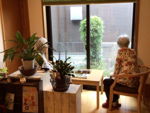 自然光差し込むラウンジ ラウンジ 大きな窓から優しい自然光が差し込むラウンジでは、居心地の良さが漂います。リラックスした雰囲気で、利用者の方々がくつろいでいます。