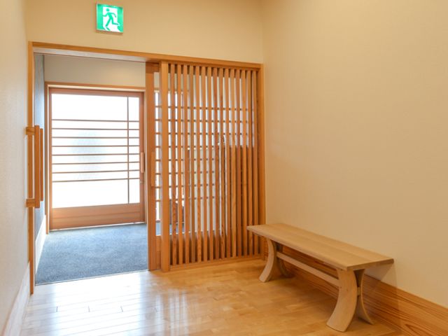 落ち着いた木製の廊下 廊下 木の温もりを感じる廊下です。シンプルなベンチが配置され、リラックスした雰囲気を演出しています。