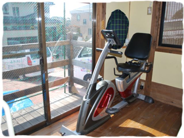 明るい光が差し込む部屋 ジム 明るい窓際に置かれたエクササイズバイクで、快適にトレーニングができます。自然光が心地よい空間です。