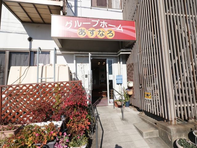 エントランスと看板の風景 外観 心温まる入り口が迎える場所です。緑に囲まれ、訪れる方々に安らぎを提供しています。