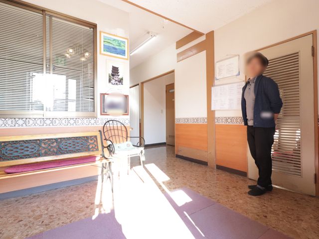 日差しが差し込むロビー 玄関 窓からの自然光が温かく差し込む、開放的なエントランスです。待合い用のベンチもあり、ゆったりとくつろげる雰囲気が漂っています。